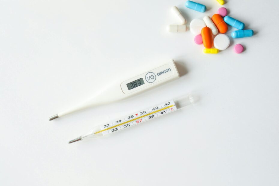 Medicines and thermometer on table; nursing interventions on fever and pyrexia