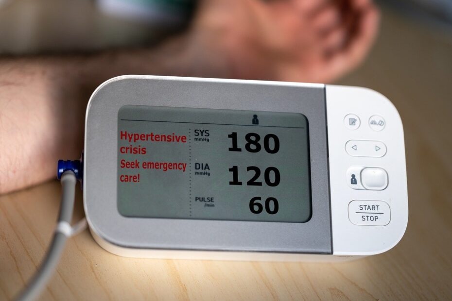 Digital blood pressure monitor displaying hypertensive crisis warning at 180/120, indicating urgent medical care needed.